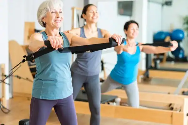 Toning Arms After 60: Empowering Womens Fitness Through Effective Weight Training 2 older woman doing weight training Wakefield and resistance in the gym to tone upper arms